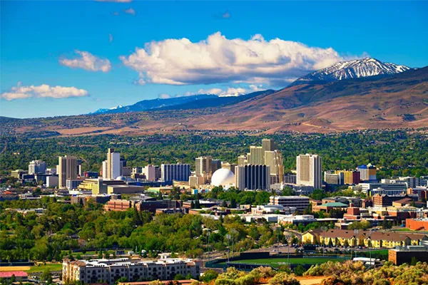Reno, Nevada business district skyline with the Sierra Nevada mountains, reflecting the region’s professional and economic environment.